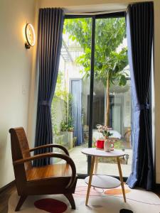 Habitación con silla, mesa y ventana en HOMEY Homestay Hue, 