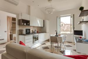 een witte woonkamer met een bank en een keuken bij WiFi Superfast!Close to Statue of David! in Florence
