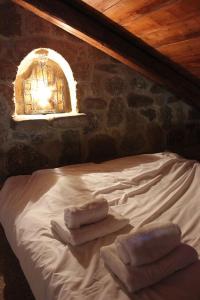 1 dormitorio con 1 cama con toallas en Helydorea zen en Synikia Mesi Trikalon