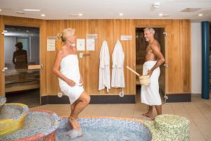 a man and a woman standing in a bath room at Gesundheit & Wellness Resort Bad Mitterndorf in Bad Mitterndorf