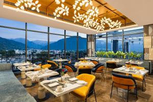 a restaurant with tables and chairs with mountains in the background at Fortune Walkway Mall, Haldwani - Member ITC's Hotel Group in Haldwāni