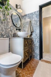 La salle de bains est pourvue de toilettes et d'un lavabo. dans l'établissement Arty Vintage Townhouse with Rooftop Shower & Sun Loungers, à Olhão