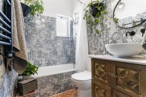 a bathroom with a sink and a toilet and a mirror at Arty Vintage Townhouse with Rooftop Shower & Sun Loungers in Olhão +22 photos