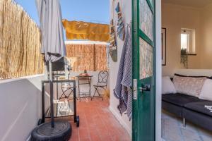 um quarto com uma porta e uma sala de estar com um sofá em Arty Vintage Townhouse with Rooftop Shower & Sun Loungers em Olhão
