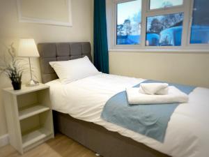 1 dormitorio con 1 cama con toallas en Davis House - 6 Beds, Sleeps up to 7, en Rothwell