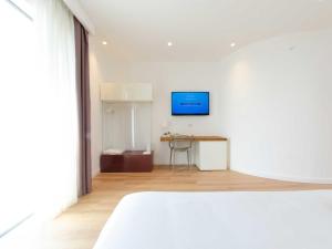 een witte kamer met een bed en een tafel bij Pascià Boutique Hotel in Ragalna