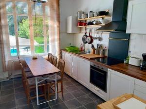 a kitchen with a table and a table and chairs at Beautiful French Holiday Villa in Saint-Junien