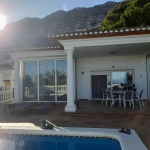 uma casa com piscina, mesa e cadeiras em Casa Harmony em Denia