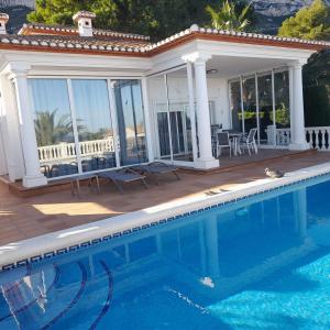 a house with a swimming pool and a patio at Casa Harmony in Denia