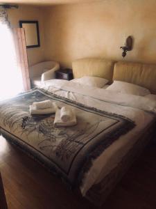 a bed with two towels and a hat on it at Helydorea zen in Synikia Mesi Trikalon