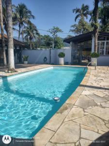 uma piscina com água azul num quintal em solar das margaridas em Paraty