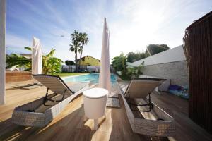 a patio with chairs and a pool and a table at Eden Luxury Villa in Focene