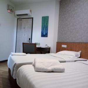 a room with two beds with white towels on them at Hotel 138 @ Bestari in Shah Alam