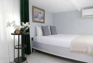 イスタンブールにあるDitto Flatsのベッドルーム(白いベッド、緑のカーテン付)