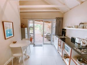 a kitchen with a table and a dining room at Pebbles Beach Cottage in Port Elizabeth