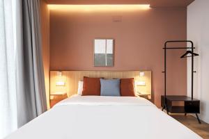 sypialnia z dużym białym łóżkiem i oknem w obiekcie Vallecas Suites by Olala Homes w Madrycie