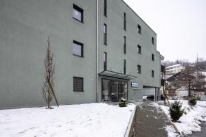 um edifício com neve em frente em Hotel Flamatt em Flamatt