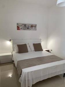 una camera bianca con un grande letto bianco di Il Canaletto Apartments a Porto Cesareo