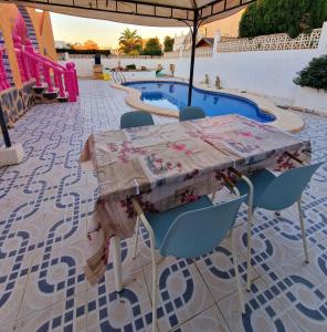 a table and chairs sitting next to a pool at Villa pink Ambience in Mazarrón