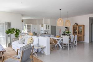 ein Wohnzimmer und eine Küche mit einem Sofa und einem Tisch in der Unterkunft Ocean Mist in Plettenberg Bay