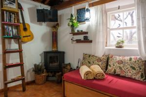 a living room with a red couch and a stove at Casa do Caramba - The Dream House in São Roque do Pico