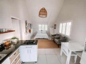 eine Küche und ein Wohnzimmer mit einem Sofa und einem Tisch in der Unterkunft Pebbles Beach Cottage in Port Elizabeth