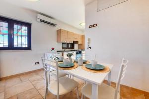 a kitchen with a table and chairs in a room at Appartamento Corallo - MyHo Casa in Torre Canne