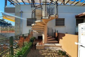 a spiral staircase on a building with a fence at Appartamento Corallo - MyHo Casa in Torre Canne +13 photos