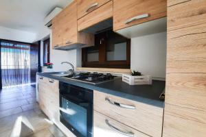 una cucina con armadi in legno e piano cottura. di Appartamento Corallo - MyHo Casa a Torre Canne