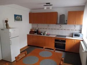 a kitchen with wooden cabinets and a table and a microwave at Casa Daubner in Cavnic