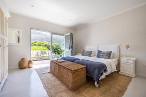 a bedroom with a bed and a large window at Ocean Mist in Plettenberg Bay