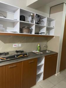 a kitchen with a counter and a sink and shelves at Asuila studio - Kiambu road Nairobi in Nairobi