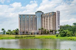 a large building next to a body of water at Pullman Sao Paulo Guarulhos Airport in Guarulhos