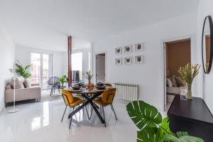 biały salon ze stołem i krzesłami w obiekcie Apartamento Embajadores VI w Madrycie