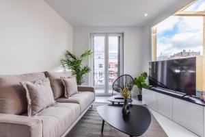 salon z kanapą i telewizorem z płaskim ekranem w obiekcie Apartamento Embajadores VI w Madrycie