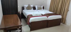 a large bed in a room with a desk and a bed sidx sidx at The Altruist Business Stays B-2 in Bangalore