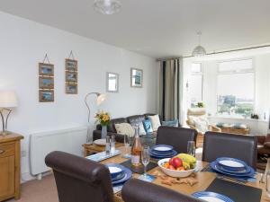 a living room with a table with a bowl of fruit on it at Pass the Keys Modern 2 Bedroom Apartment with stunning Sea Views in Trearddur