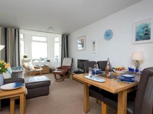 a living room with a dining table and a living room at Pass the Keys Modern 2 Bedroom Apartment with stunning Sea Views in Trearddur
