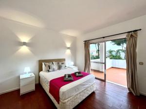 una camera con un letto e una grande porta scorrevole in vetro di Vilamoura Ocean Villa with Pool by Homing a Vilamoura