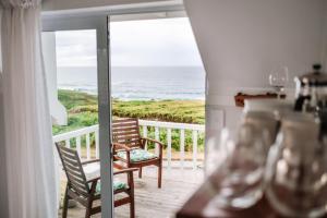 a room with a balcony with a view of the ocean at Pebbles Beach Cottage in Port Elizabeth