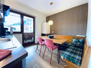富爾普梅斯的住宿－Königin Serles - großzügig, gemütlich & nachhaltig，厨房配有木桌和2把粉红色的椅子