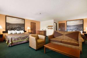 a hotel room with a bed and a chair at Super 8 by Wyndham Concordia in Concordia