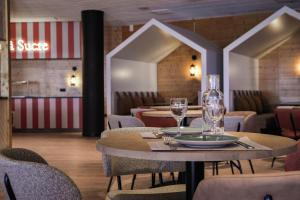 アヴォリアーズにあるBelambra Clubs Avoriaz - Les Cimes du Soleilのテーブルと椅子(ガラス付)が備わるレストラン