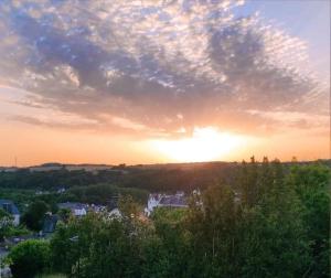 a sunset over a city with the sun in the sky at Jolie petite maison indépendante de plain-pied in Pont-de-Buis