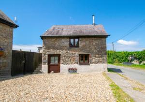 a stone house with a driveway in front of it at Granary Cottage in Knelston