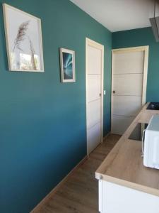 a kitchen with blue and green walls and a counter at Jolie petite maison indépendante de plain-pied in Pont-de-Buis