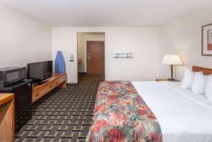 a hotel room with a bed and a flat screen tv at Baymont by Wyndham Decatur in Decatur