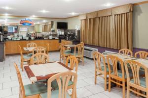 un restaurante con mesas y sillas y una cocina en Baymont by Wyndham Decatur, en Decatur