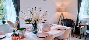 a dining room table with a vase of flowers on it at Sunny-side-up in St Austell