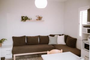 un soggiorno con divano marrone di Pebbles Beach Cottage a Port Elizabeth